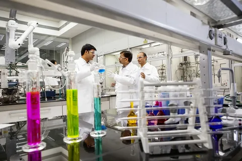 Three men in lab coats and a rack of test tubes.